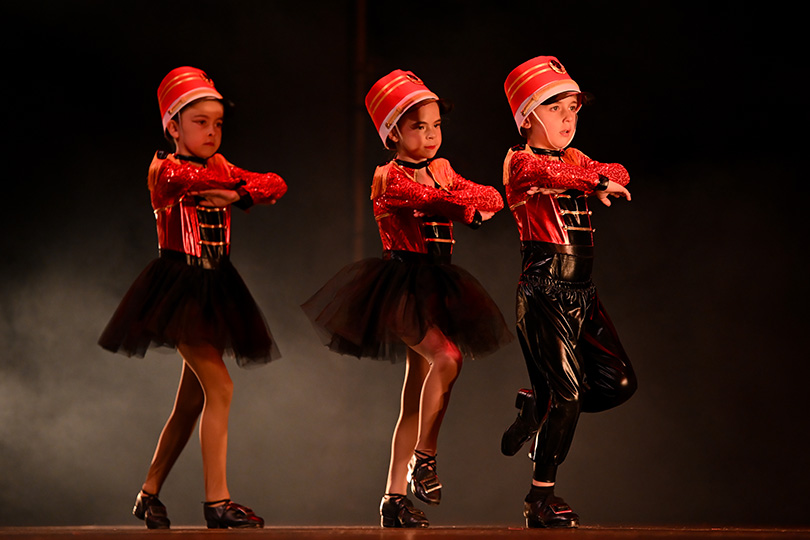 Three young dancers wear soldier uniforms for the production of the Nutcracker